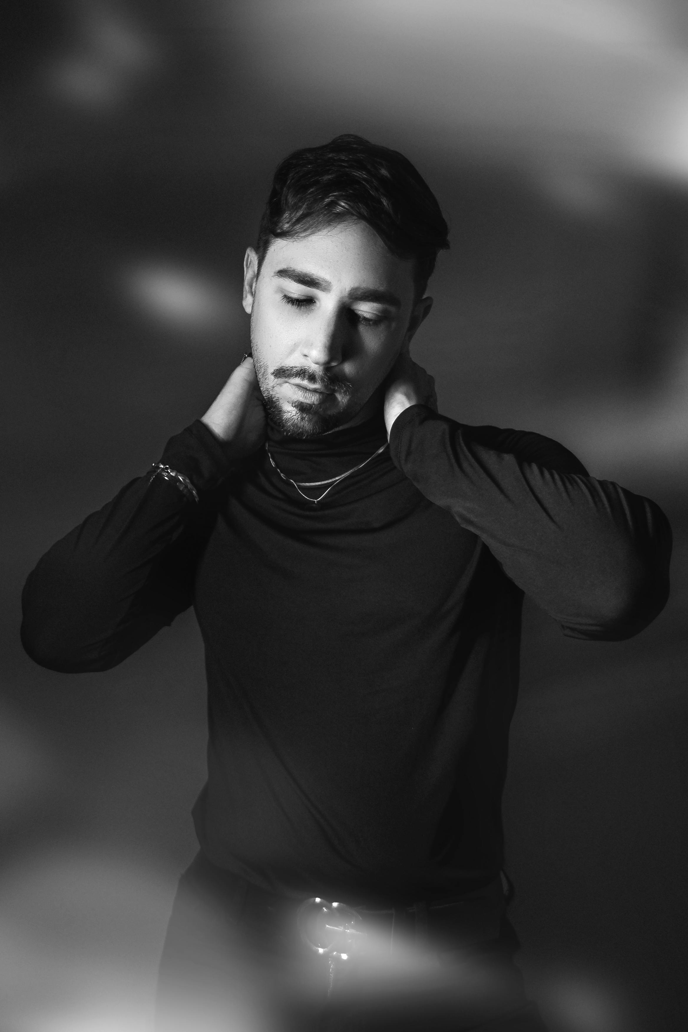 бесплатная Созерцательный черно-белый портрет мужчины при художественном студийном освещении, вызывающий настроение и самоанализ. Стоковое фото