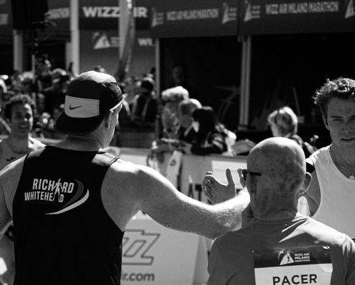 Free Runners celebrate at a marathon finish line, capturing the joy and relief of completion. Stock Photo