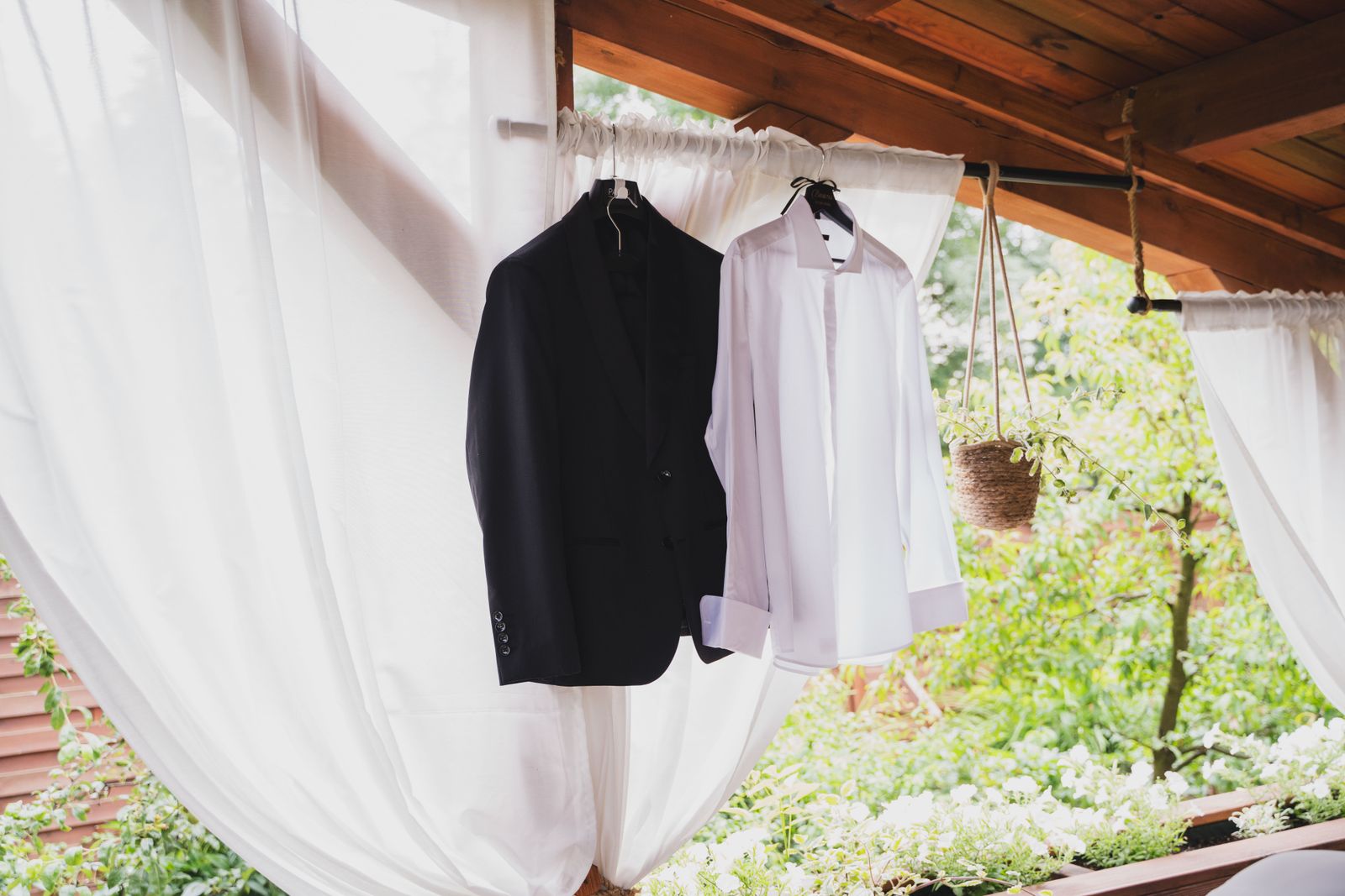 White shirt and dark suit hanging outdoors with no people