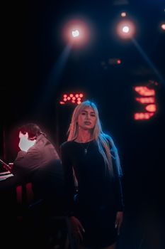 A young woman stands confidently in a nightclub, bathed in colorful dramatic lighting.