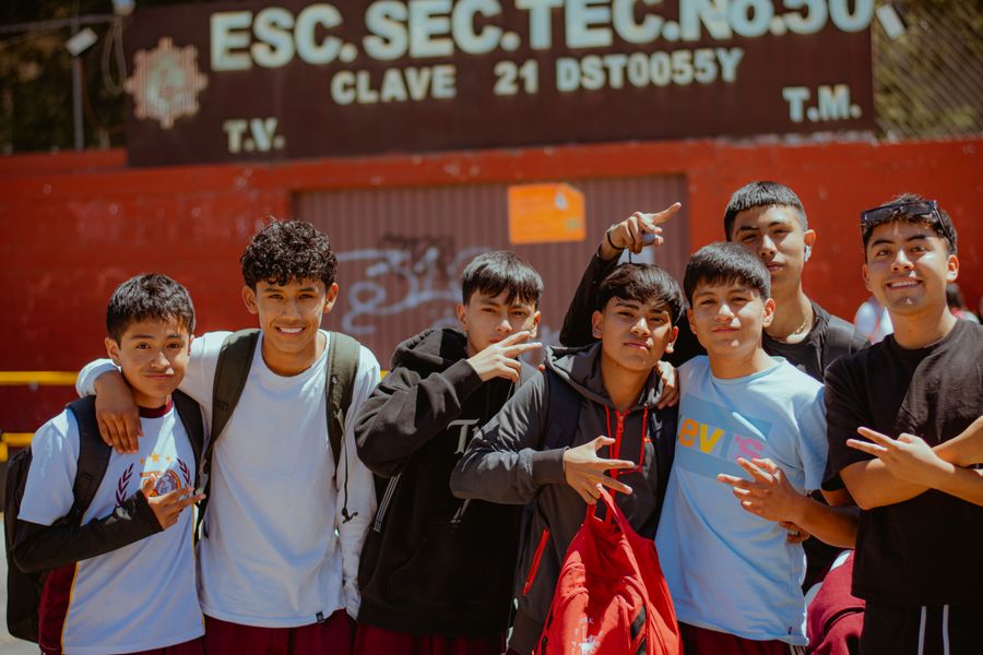 A group of teenagers outside their school on a sunny day