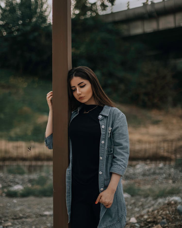 Woman Standing Beside Brown Wooden Post