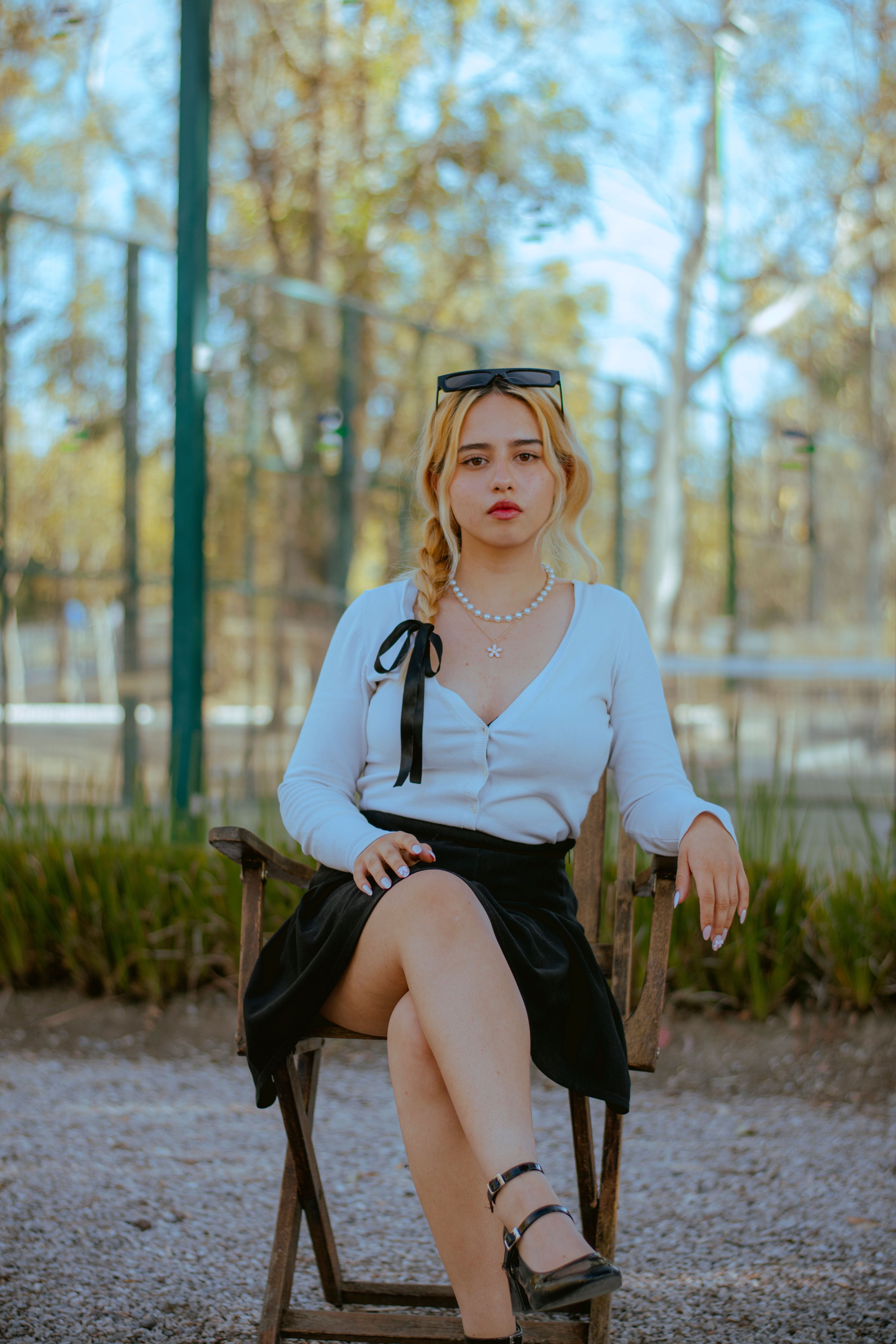 Young Woman Sitting Outdoors in Stylish Attire · Free Stock Photo