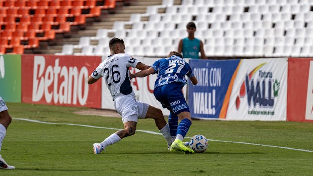 Intense soccer match with players battling for the ball near the sideline.