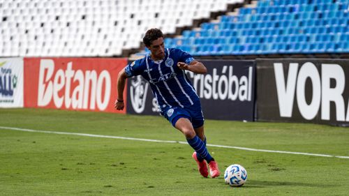 Free Soccer player dribbling the ball during a match on a sunny day. Stock Photo