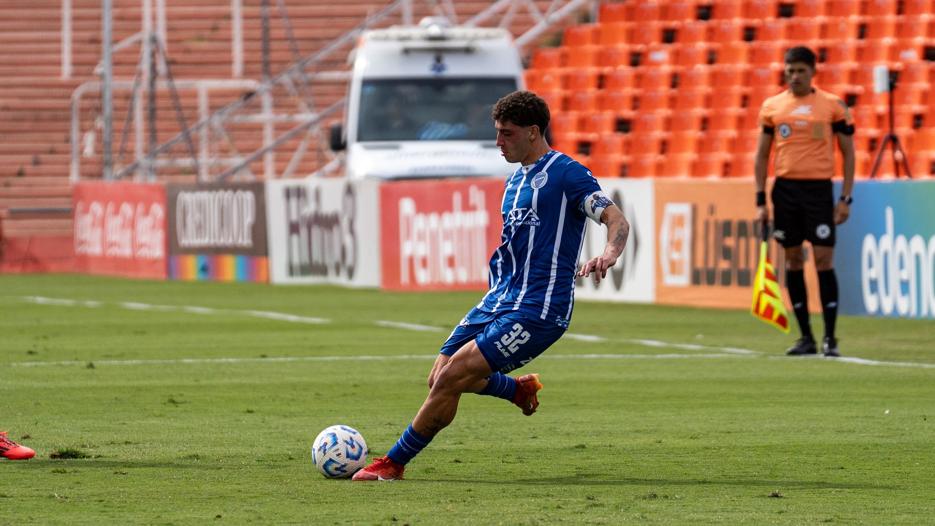 Action shot of a soccer player kicking the ball during a competitive stadium match.