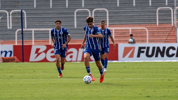 Action-packed soccer game with players in blue uniforms on the field.