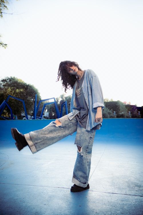 Free Young adult showcasing fashion style in a vibrant skatepark setting. Stock Photo