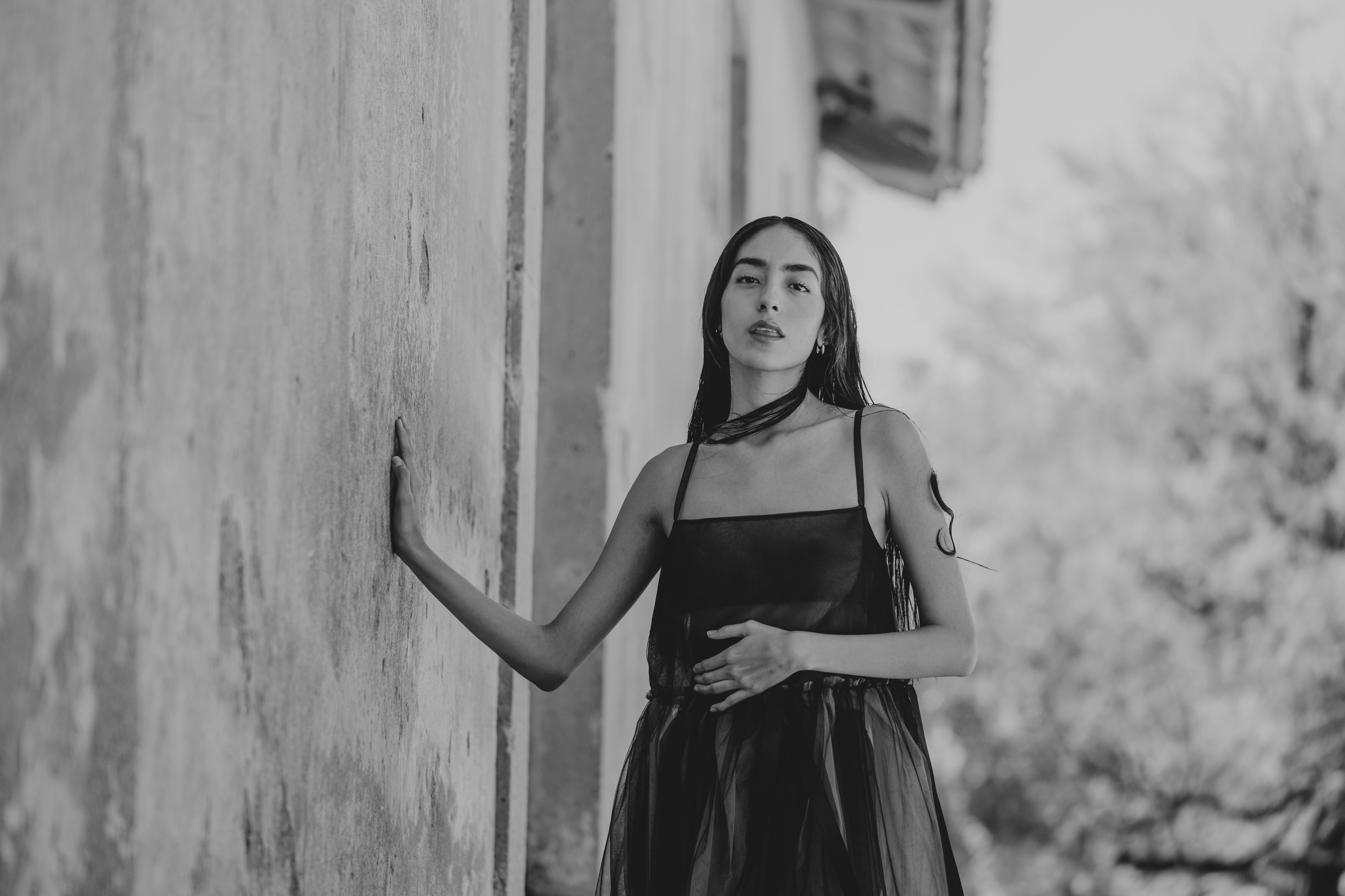 Elegant Woman in Black Dress Leaning Against Wall · Free Stock Photo