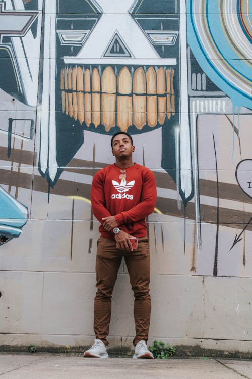 Man Leaning on Wall With Mural