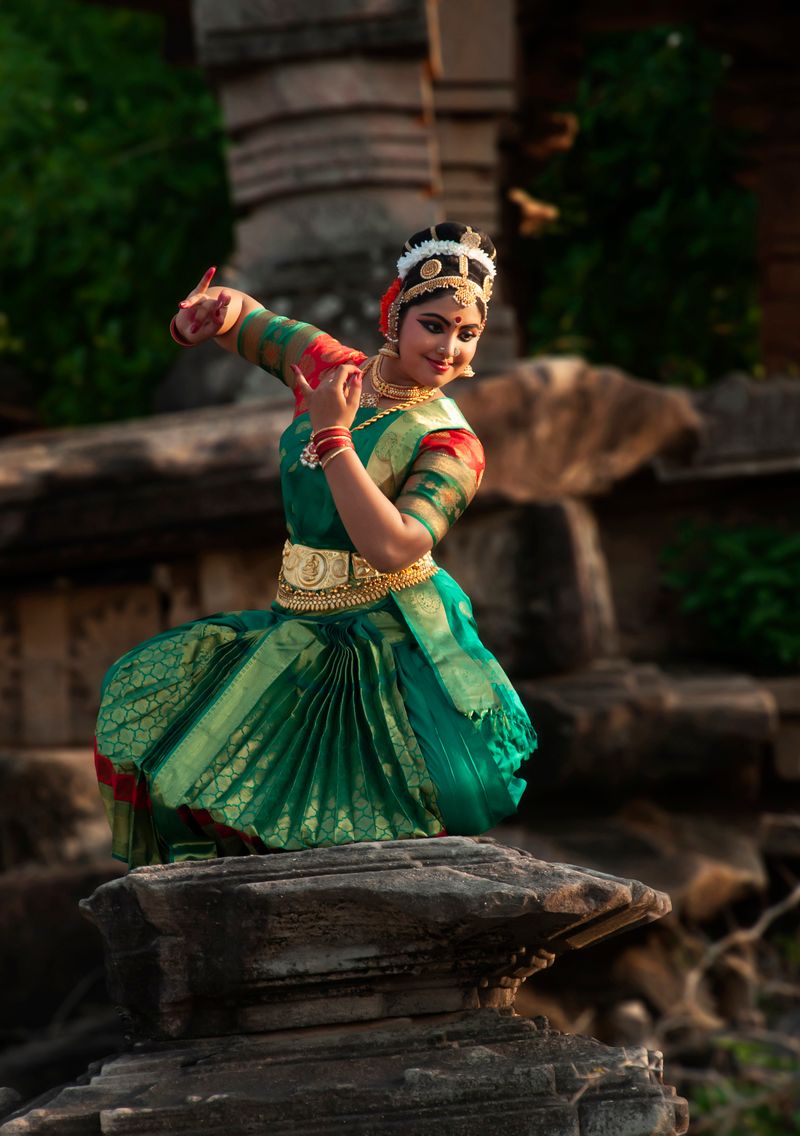 Classical Indian dancer in vibrant attire against a historic backdrop