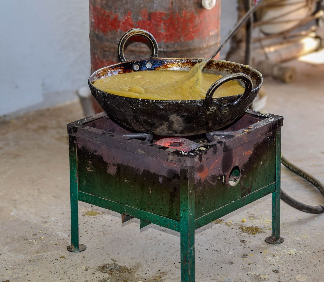 Black cast iron kadhai on a stove outdoors
