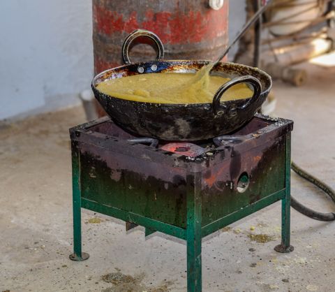 Black cast iron kadhai on a stove outdoors