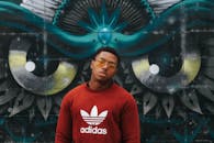 在弗吉尼亚州里士满，一名男子在一幅充满活力的涂鸦前摆姿势拍摄艺术肖像