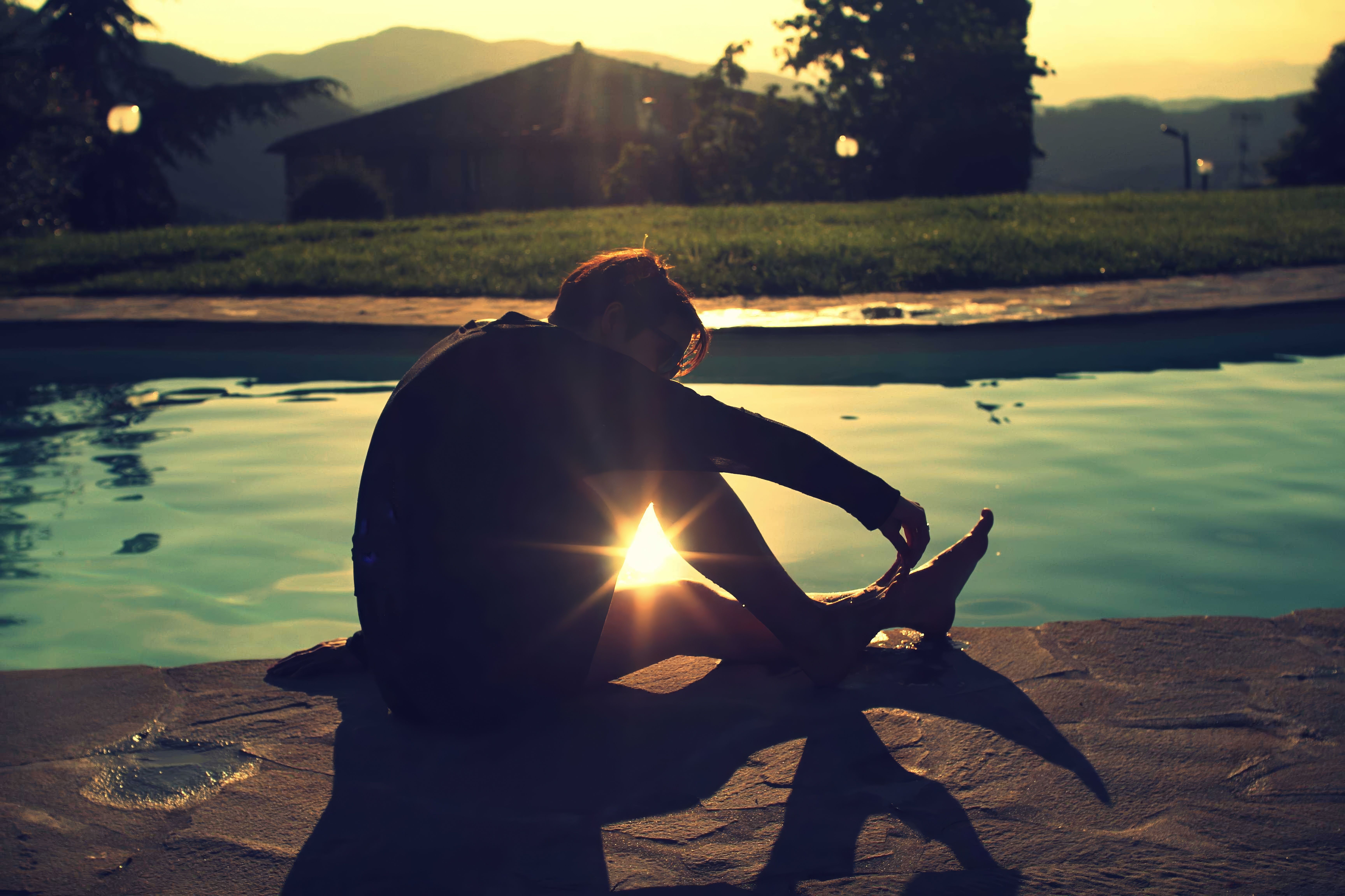 Contemplative Woman by Pool at Sunset · Free Stock Photo