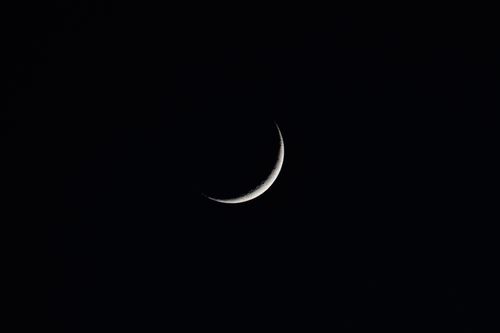 Free A serene crescent moon against a dark night sky, perfect for backgrounds and atmospheric designs. Stock Photo