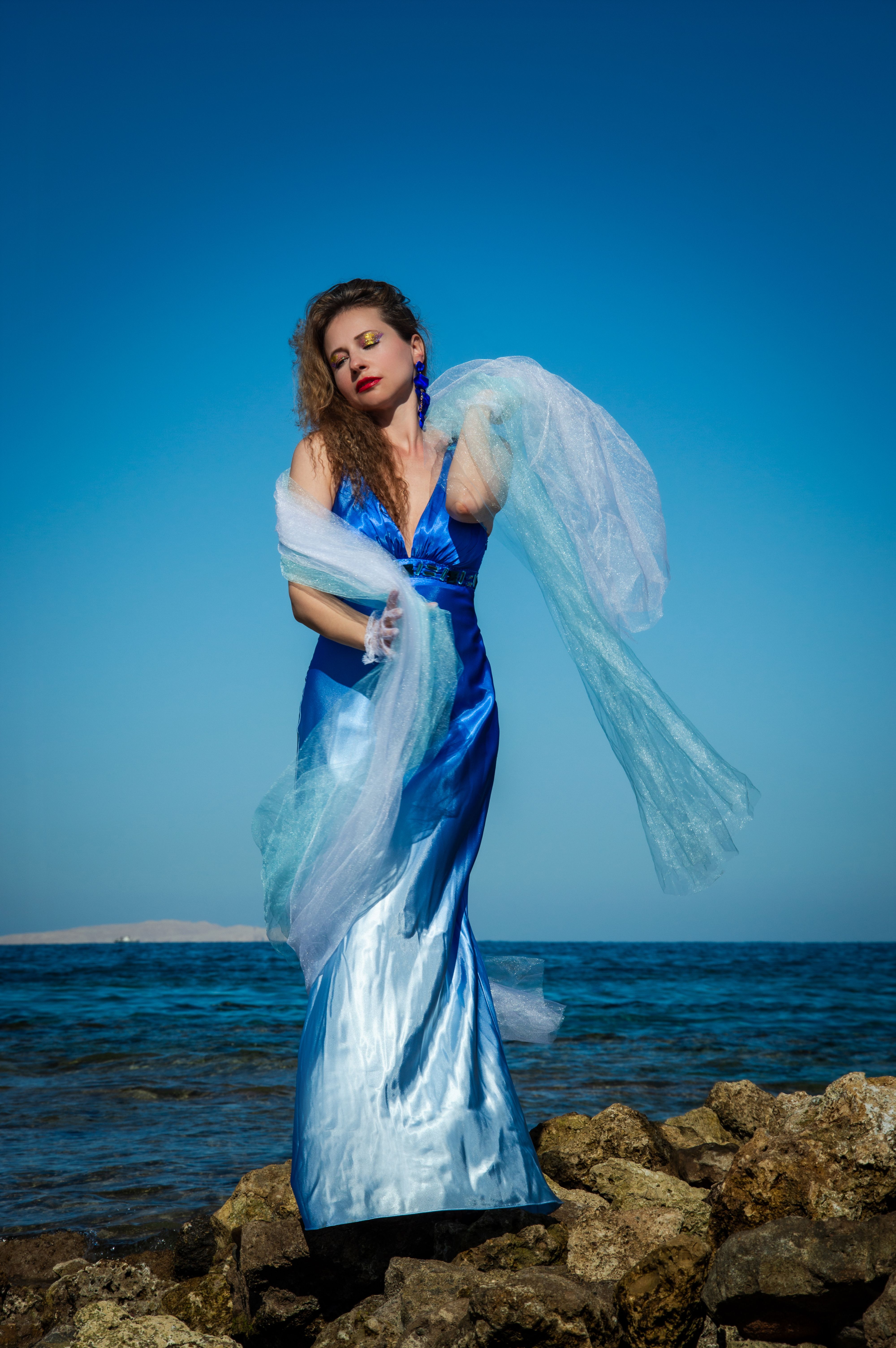 Elegant Woman in Blue Gown by the Sea Shore · Free Stock Photo