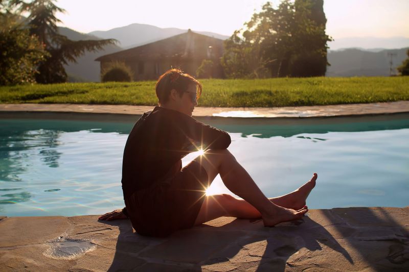 Piscină la o vilă din Toscana, cu șezlonguri și vedere spre dealuri