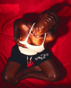 Dynamic portrait featuring a young woman in an expressive pose on a vivid red backdrop.