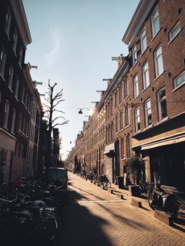 Scenic Amsterdam street view with classic architecture and bicycles in warm lighting.