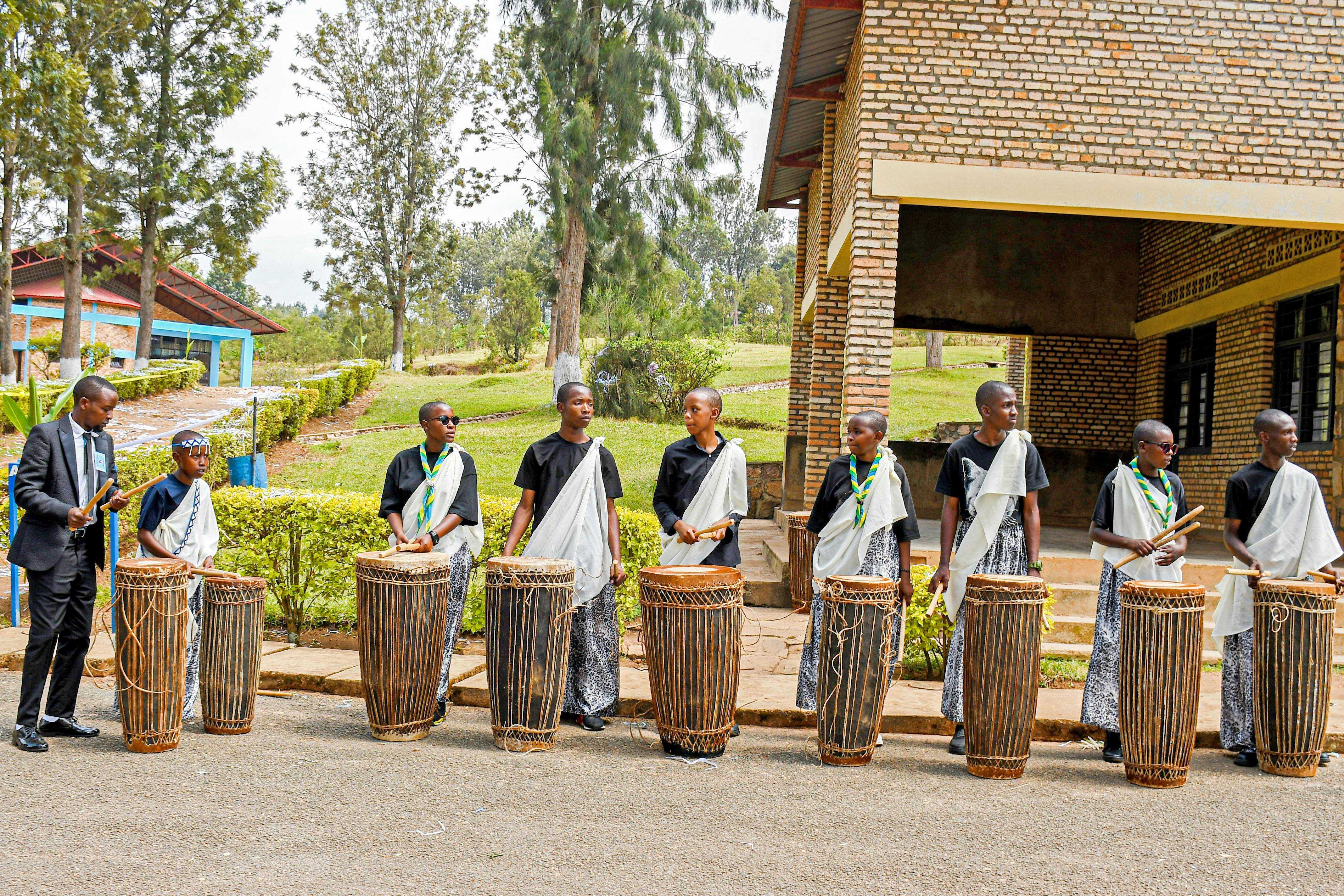 A vibrant outdoor traditional drumming performance in Rwanda with a group of musicians.