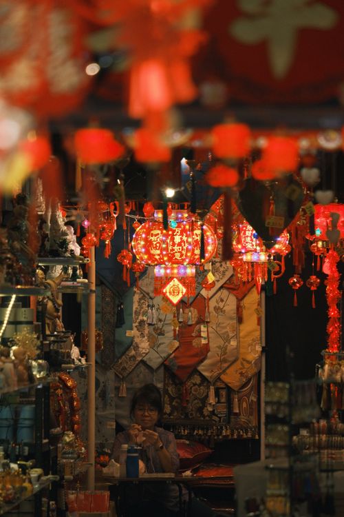 Free A bustling Asian market filled with vibrant red Chinese lanterns and festive decorations. Stock Photo
