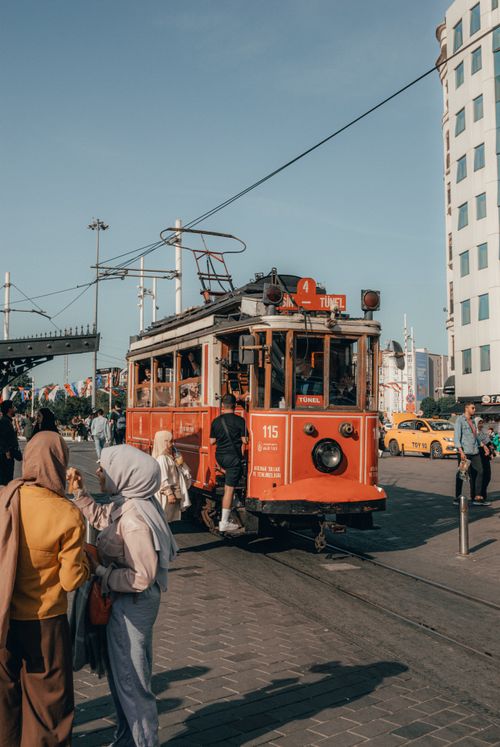 Free Red tram in Taksim Square, Istanbul, with people enjoying a sunny day. Stock Photo