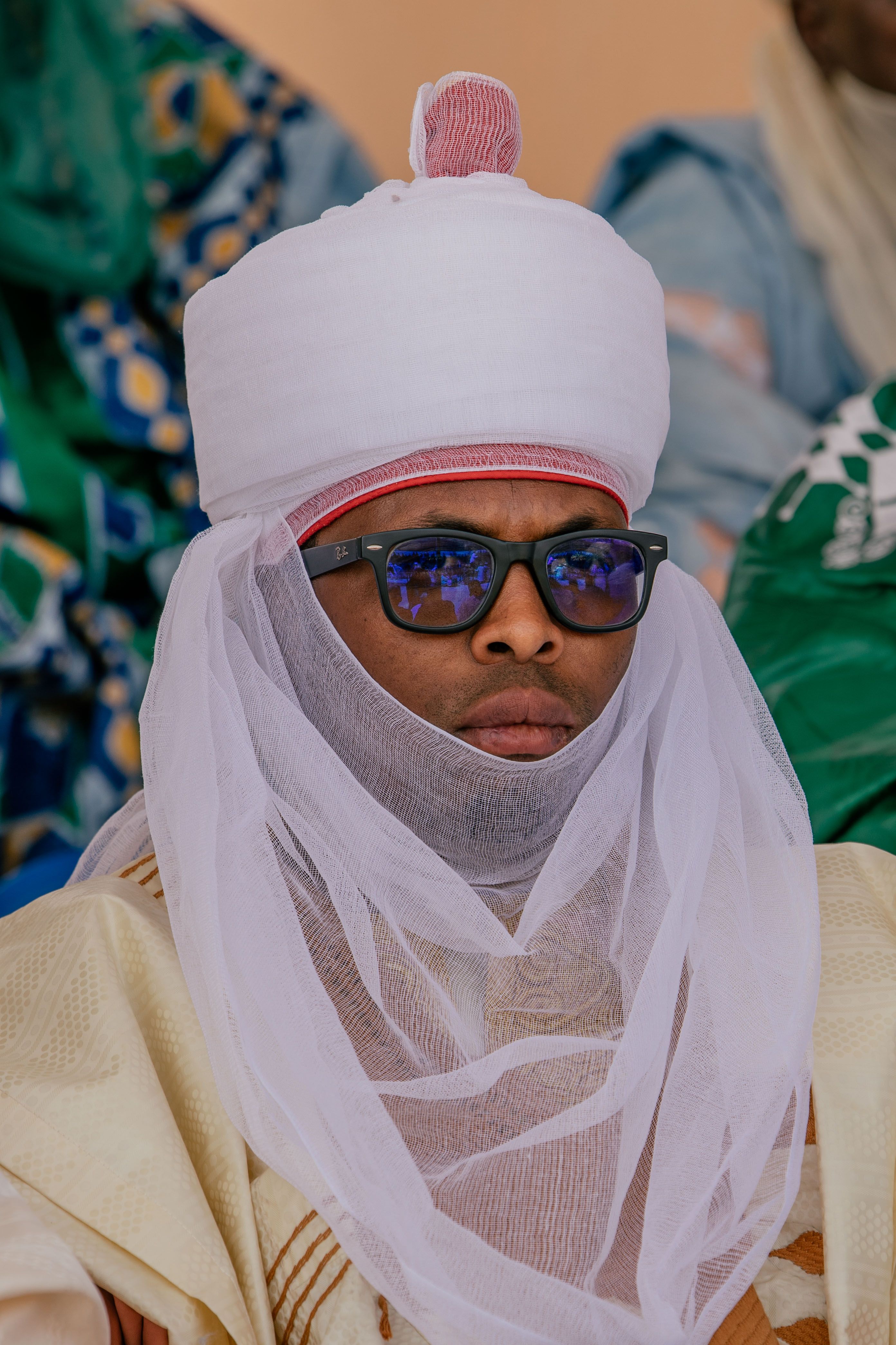 Portrait of a person in traditional African clothing with turban and veil, exuding cultural richness.