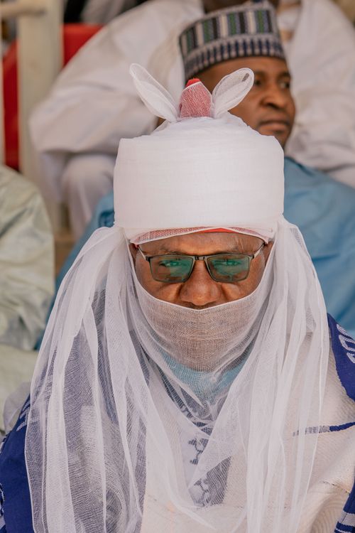 Free African leader wearing traditional attire with headwrap and sunglasses at cultural event. Stock Photo