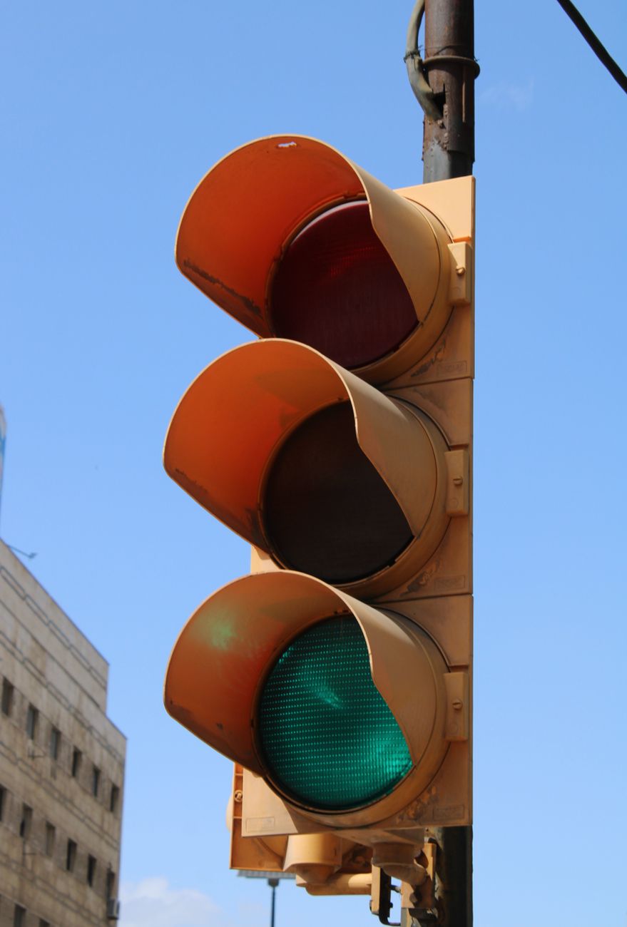 Traffic light displaying green signal on a clear day with blue sky backdrop.