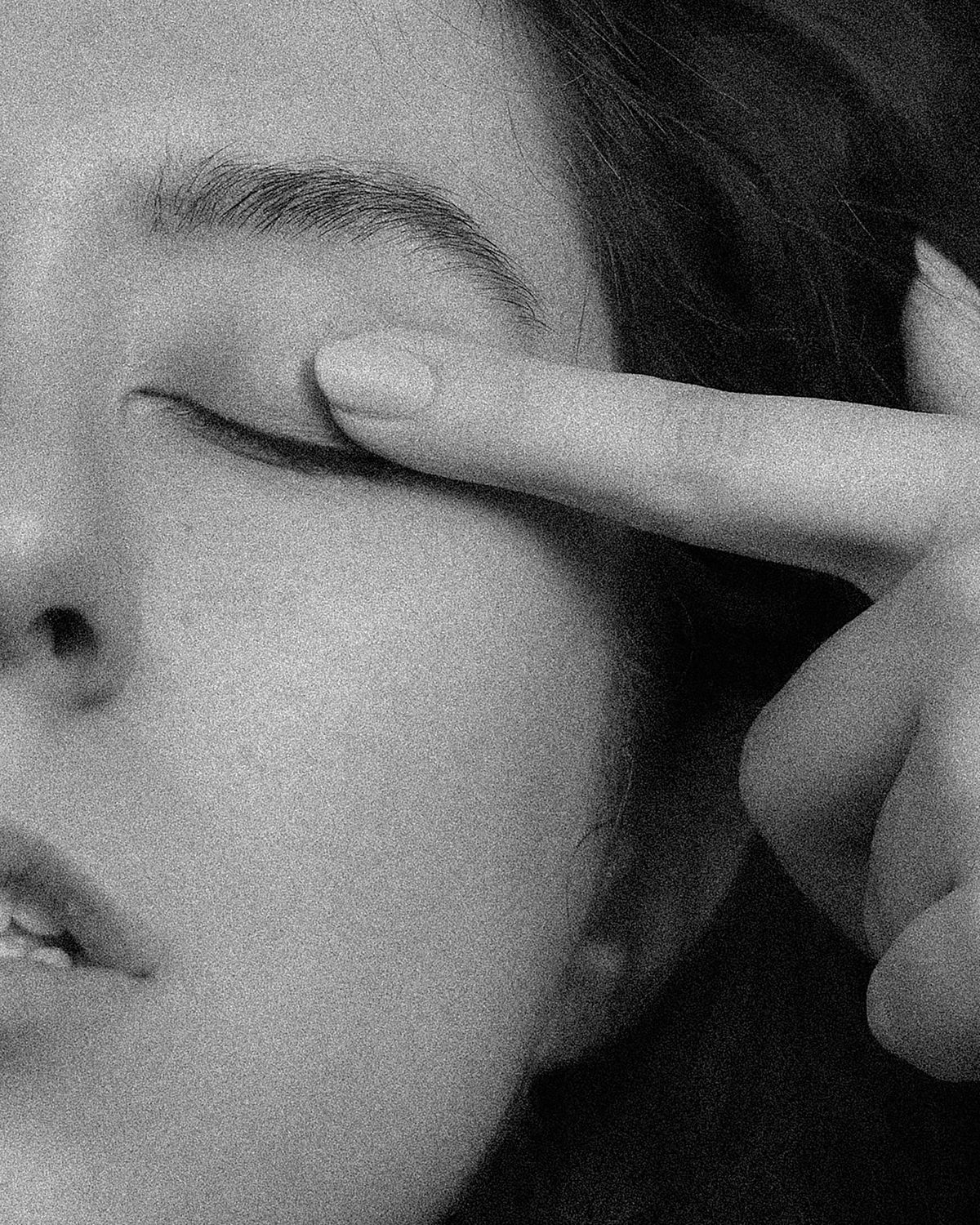 Woman resting with her eyes closed, touching her eyelid