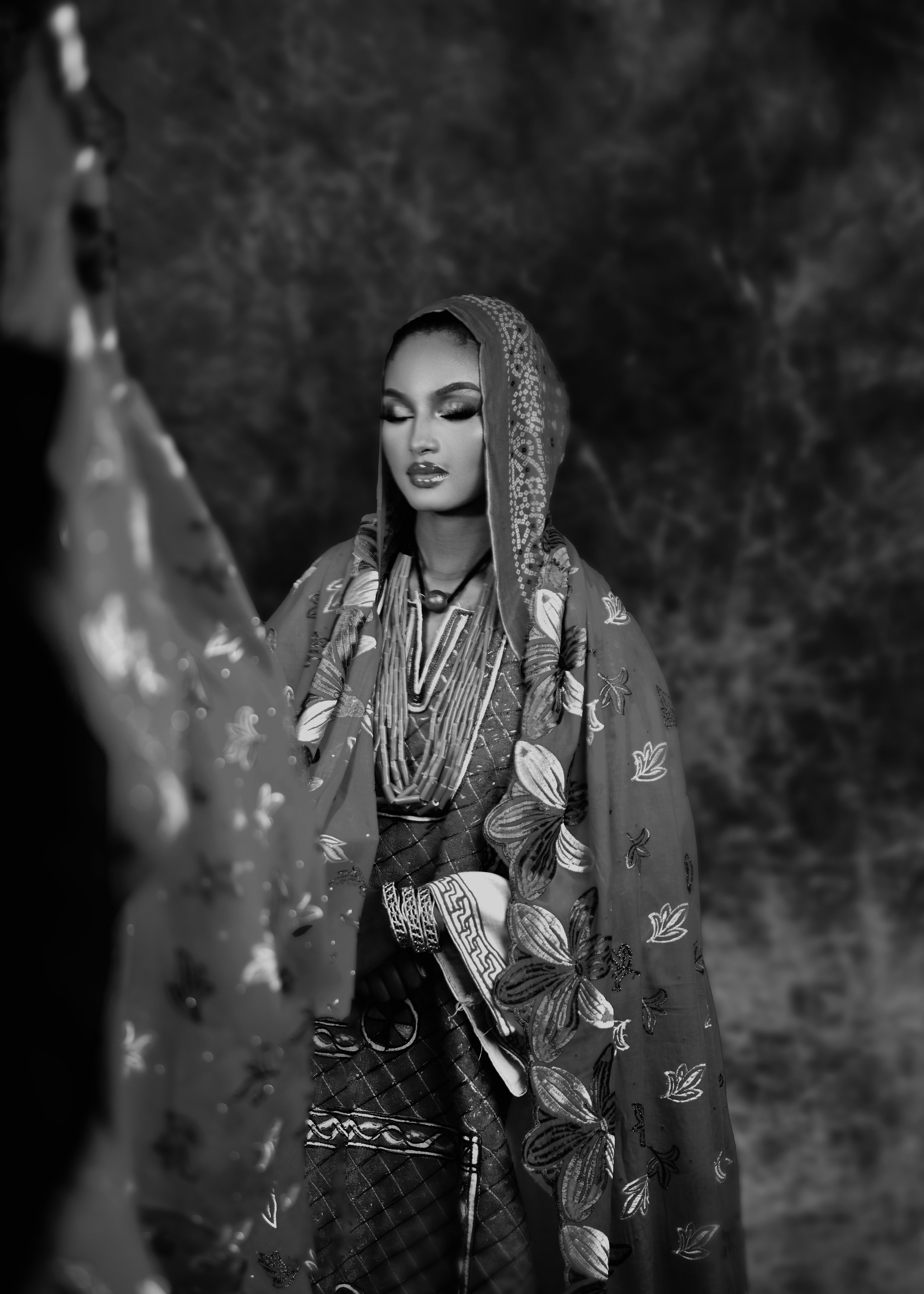 Black and white portrait of a woman in traditional Nigerian attire, showcasing cultural beauty.