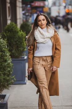 白天，一位穿着休闲服的时尚女性走在纽约市的人行道上