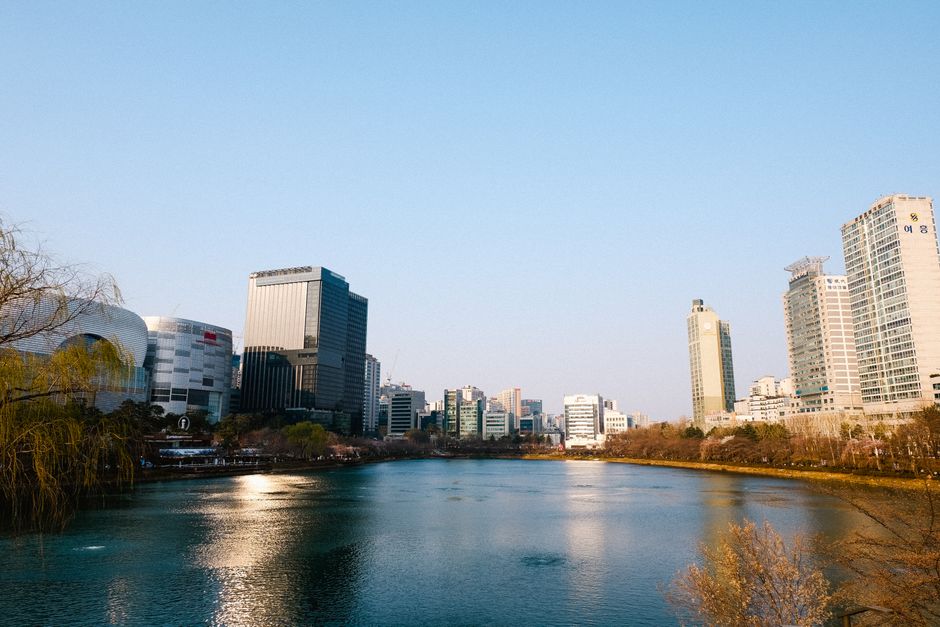 Calm urban skyline photo over a tranquil river on a clear day.