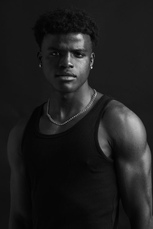 Free Black and white portrait of a confident male model posing with a serious look in a studio setting. Stock Photo