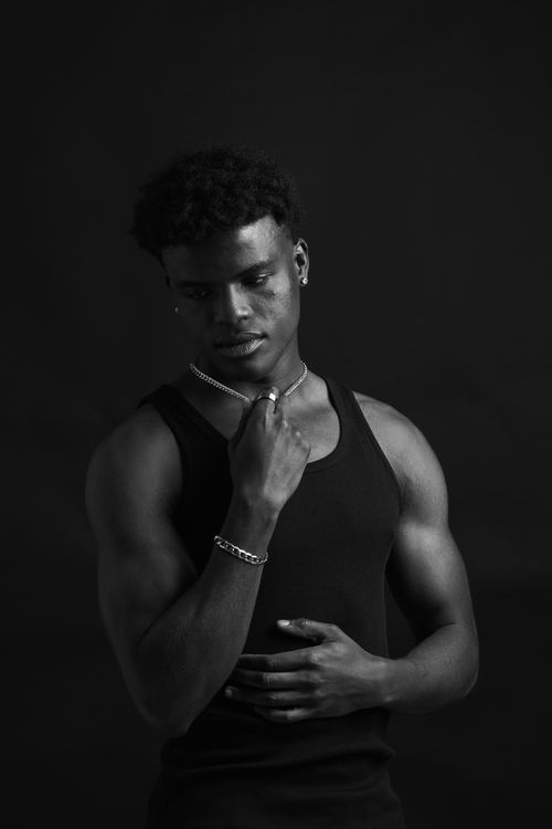 Free Striking black and white portrait of a serious male model posing indoors. Stock Photo