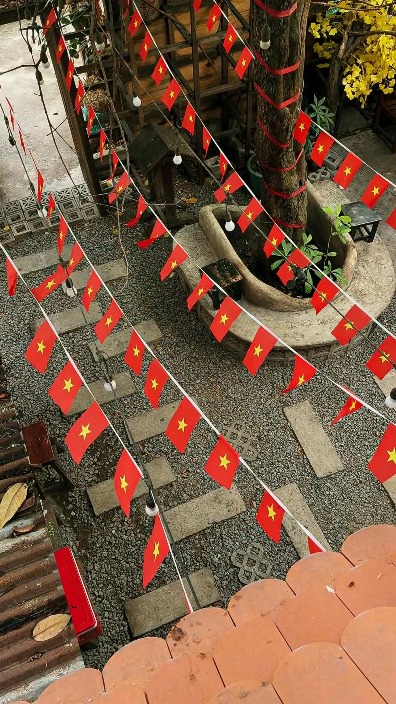 Vietnamese flags strung across a courtyard in Ho Chi Minh City, capturing a festive atmosphere.