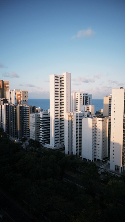 Free Aerial view of urban high-rise buildings near the coast during daytime, clear sky. Stock Photo