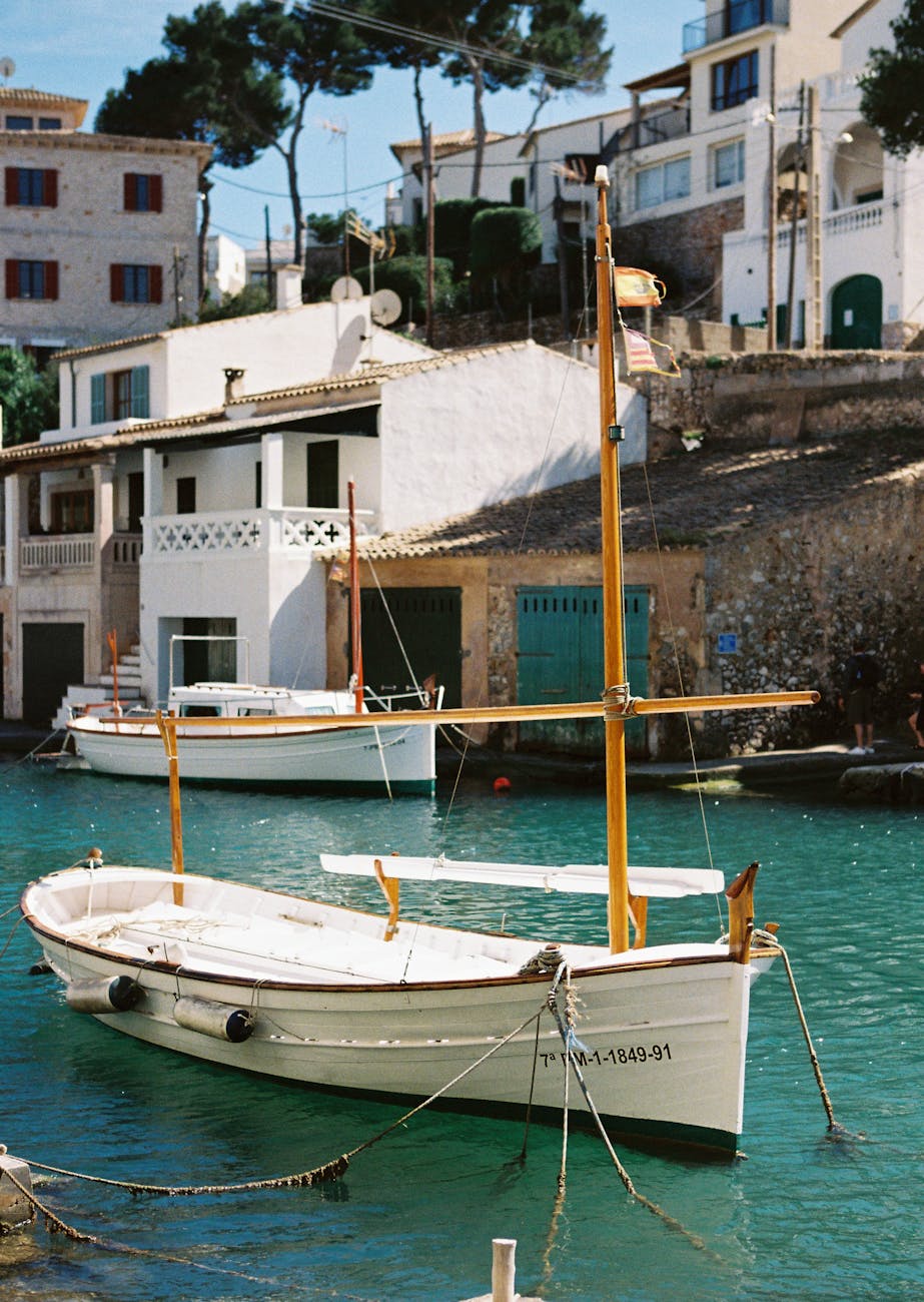Charming wooden boat anchored in the scenic harbor of Cala Figuera, Balearic Islands.