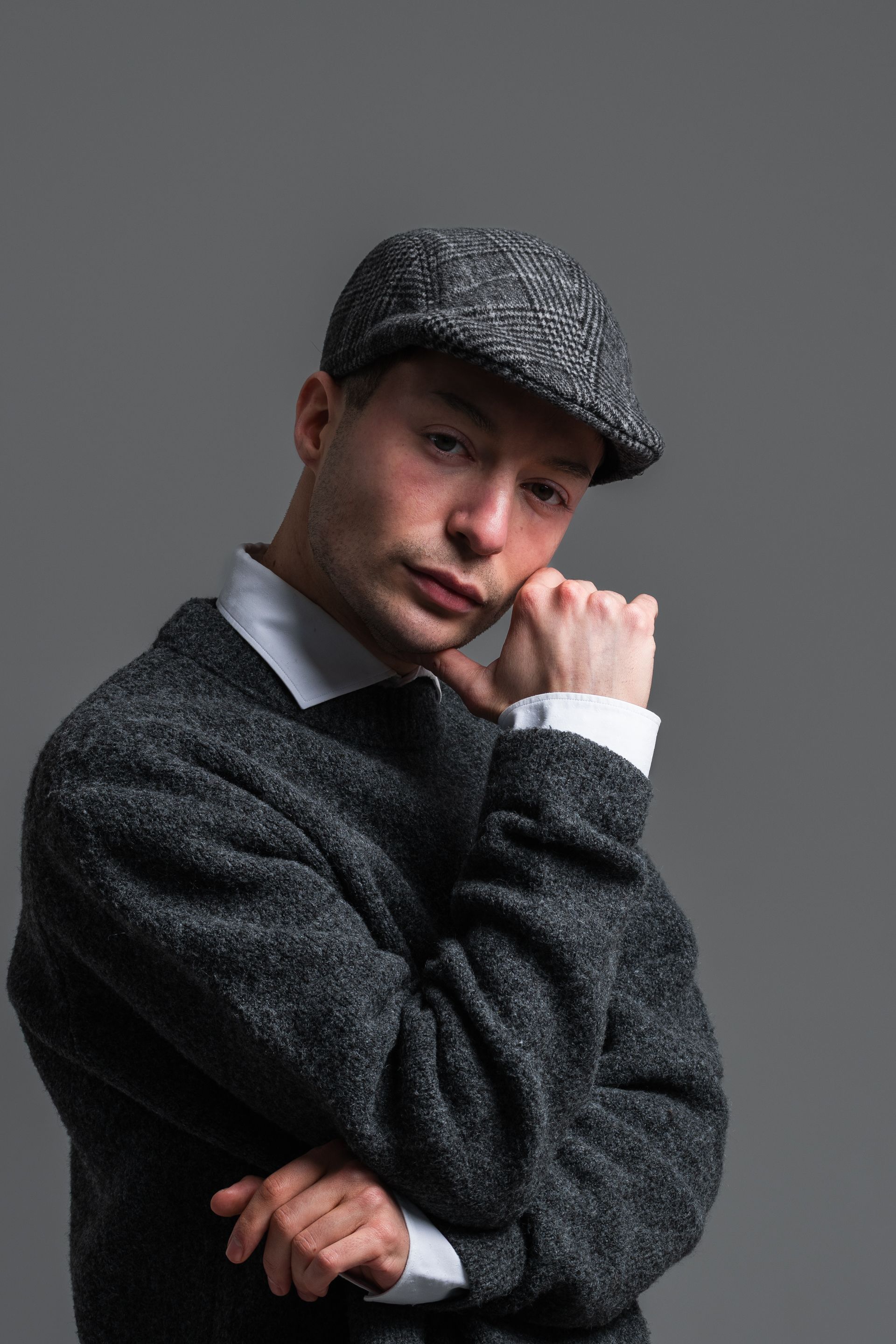 Stylish Man in Tweed Cap Posing Thoughtfully · Free Stock Photo