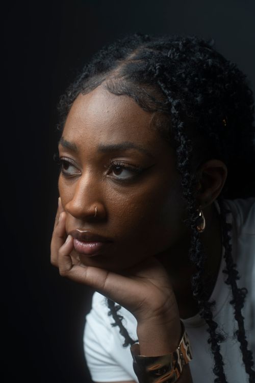 Free A thoughtful African model poses in a studio setting, capturing beauty and emotion. Stock Photo