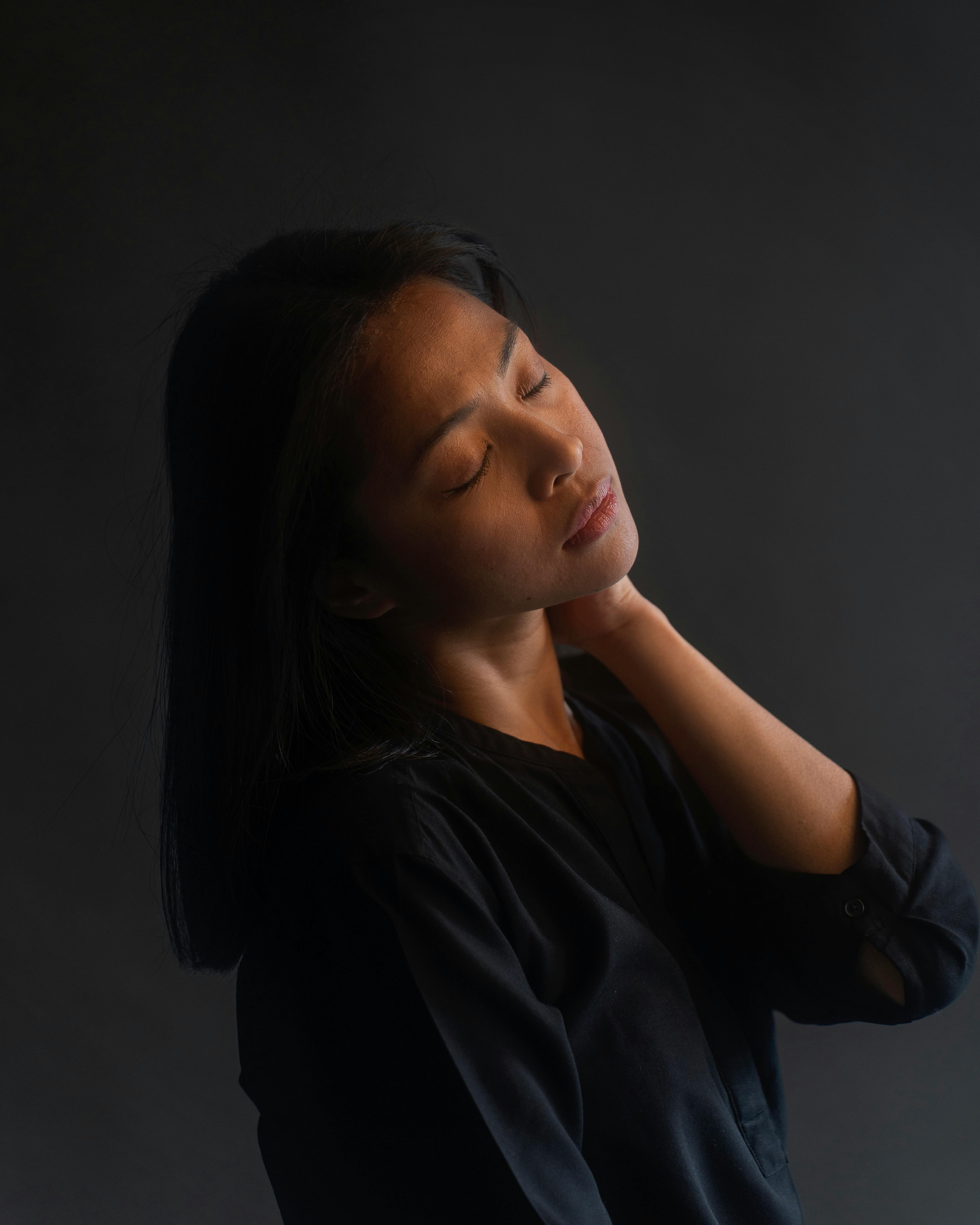 Captivating portrait of a serene Asian woman posing indoors in Berlin, embracing peaceful introspection.