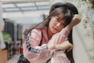 一位穿着休闲服、戴贝雷帽、靠在栏杆上的年轻女子的户外肖像