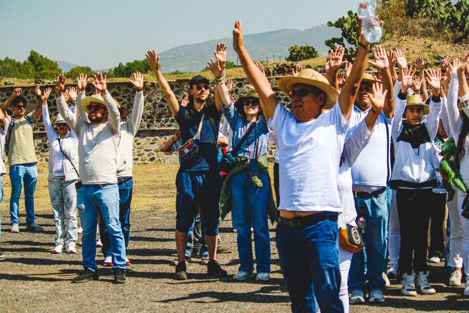 A group of adults exercising outdoors at the historic Teotihuacán pyramids in Mexico.