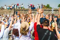 A lively crowd raising hands in celebration at Teotihuacán, Mexico, capturing rich cultural ambiance.