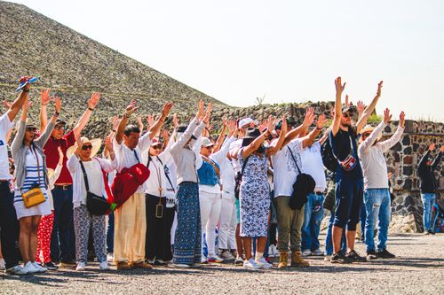 Free A group of tourists raising hands at the Pyramids of Teotihuacán, Mexico. Stock Photo