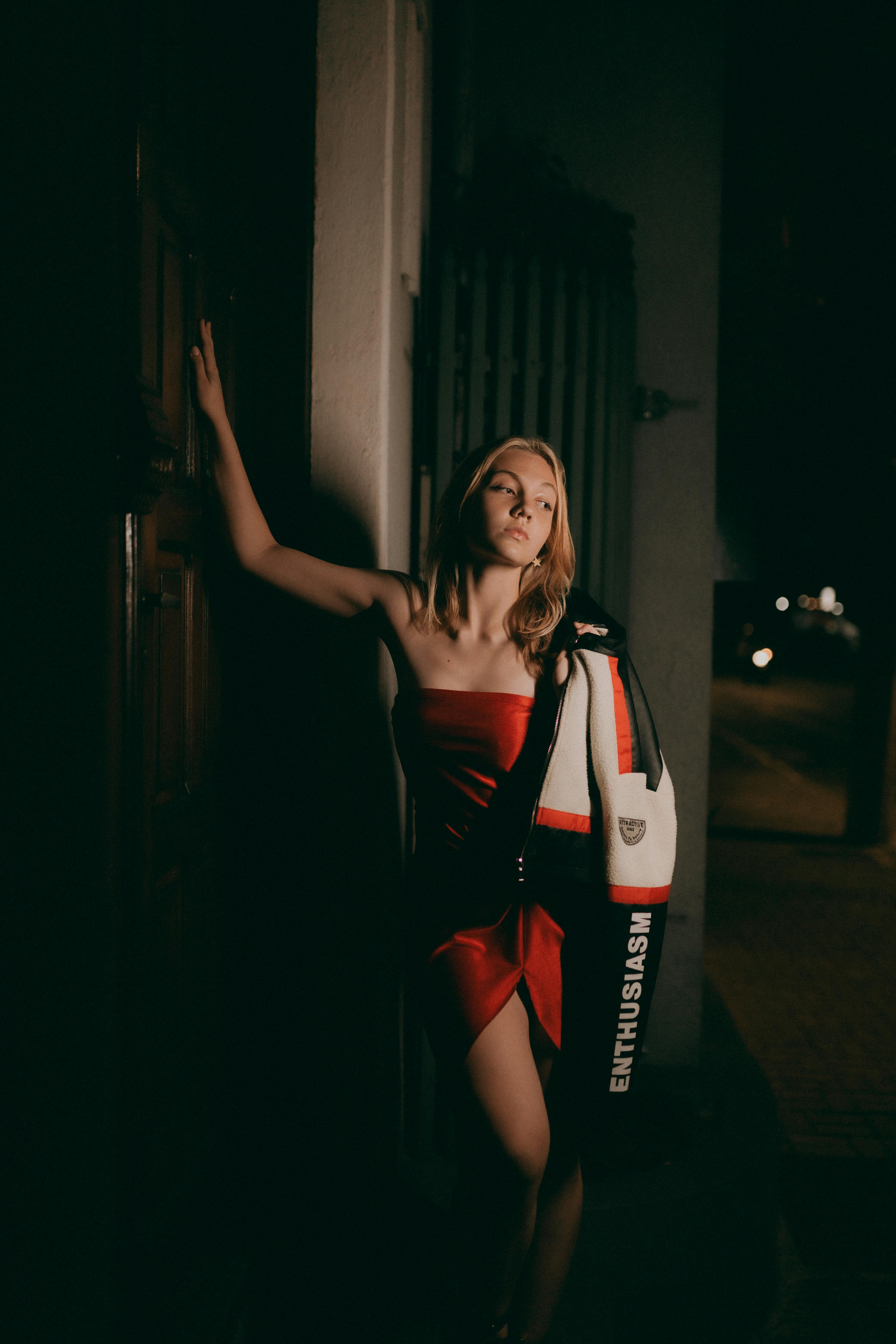 Fashion portrait of a woman in red dress at night, showcasing style and elegance.