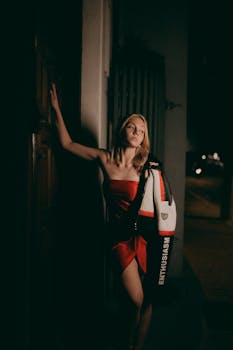 Fashion portrait of a woman in red dress at night, showcasing style and elegance.