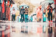在北京多雨的街道上，人们打着雨伞，展现出充满活力的城市生活