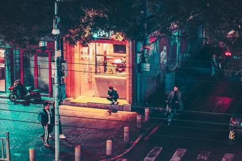 Free A lively night street scene in Beijing with people, bicycles, and a café. Stock Photo